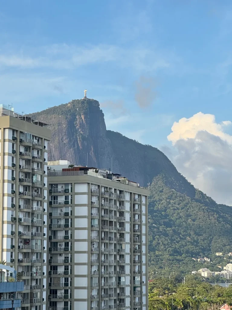 Il Cristo visto dal quartiere, sopra i palazzi di Rio. Dicembre 2025.