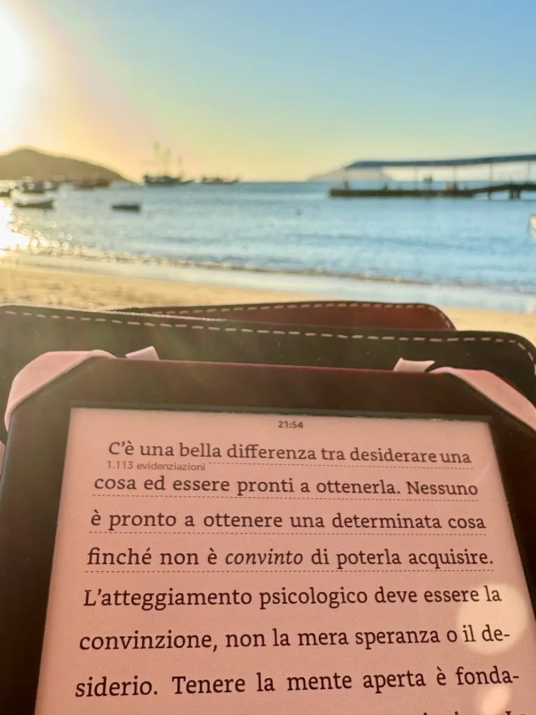 Leggere in spiaggia a Búzios, con le barche davanti. Agosto 2024.
