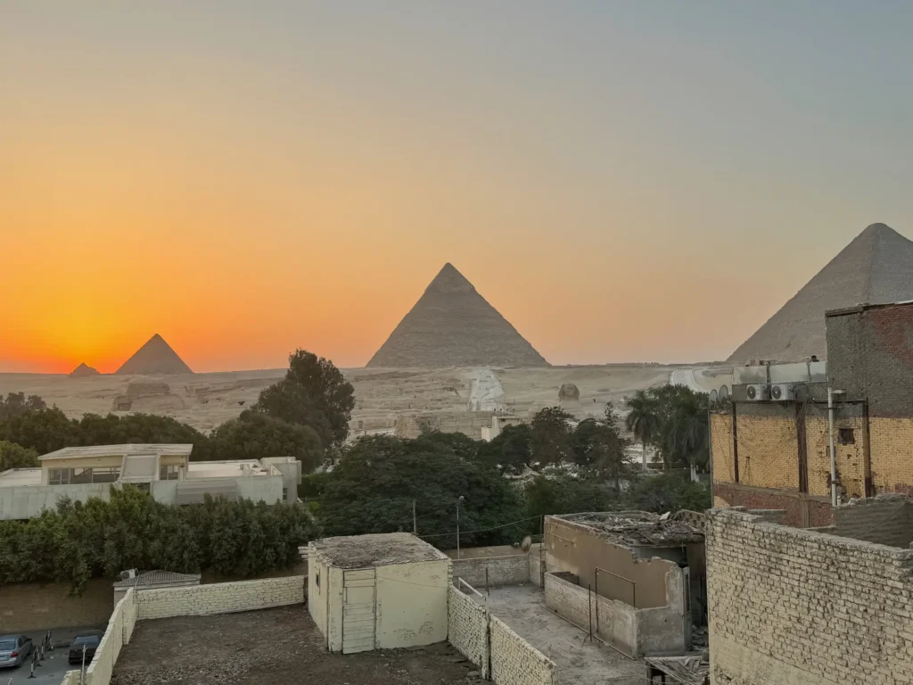 Le piramidi sopra i tetti di Giza: la città arriva fino al recinto. Ottobre 2023.