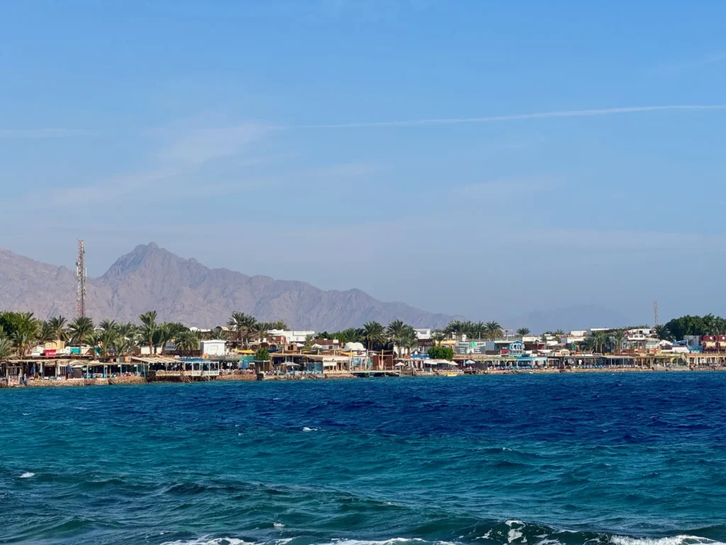Dahab vista dall’acqua, con la parete del Sinai dietro. Novembre 2023.