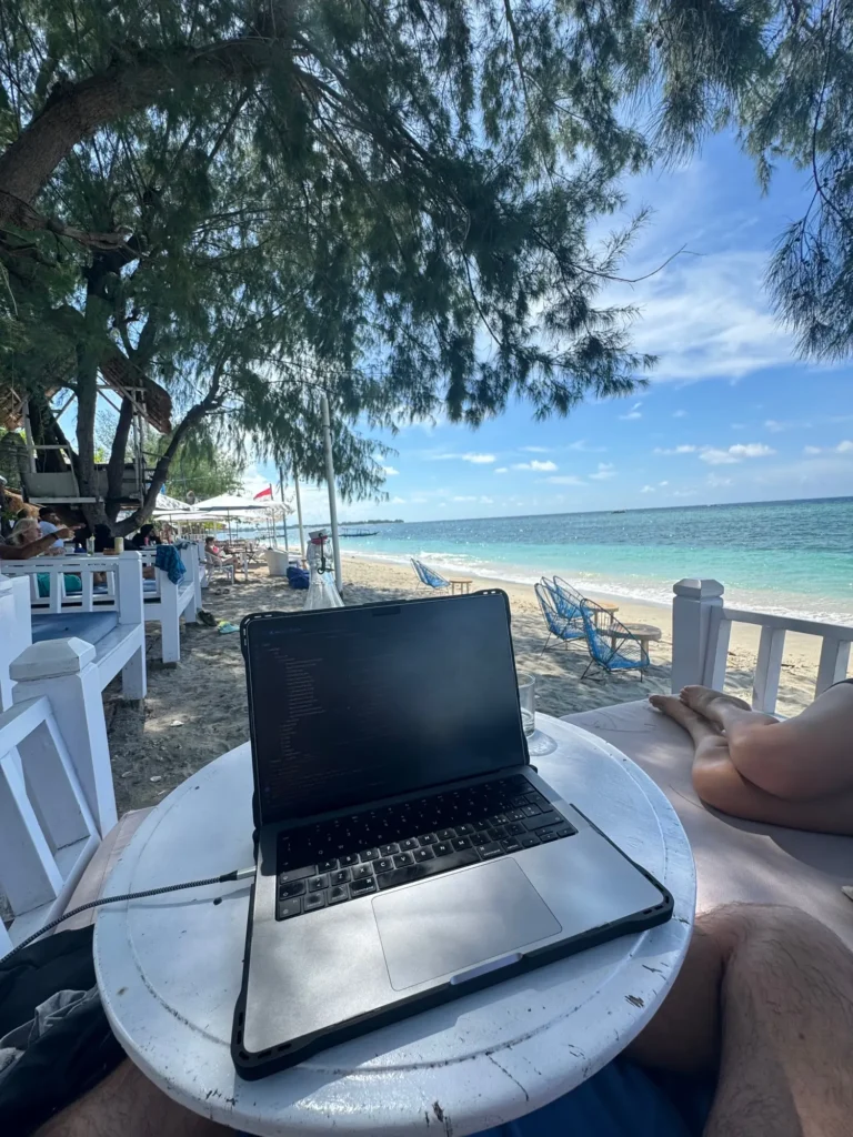 Il portatile sul tavolino davanti alla spiaggia, a Gili Air. Febbraio 2024.