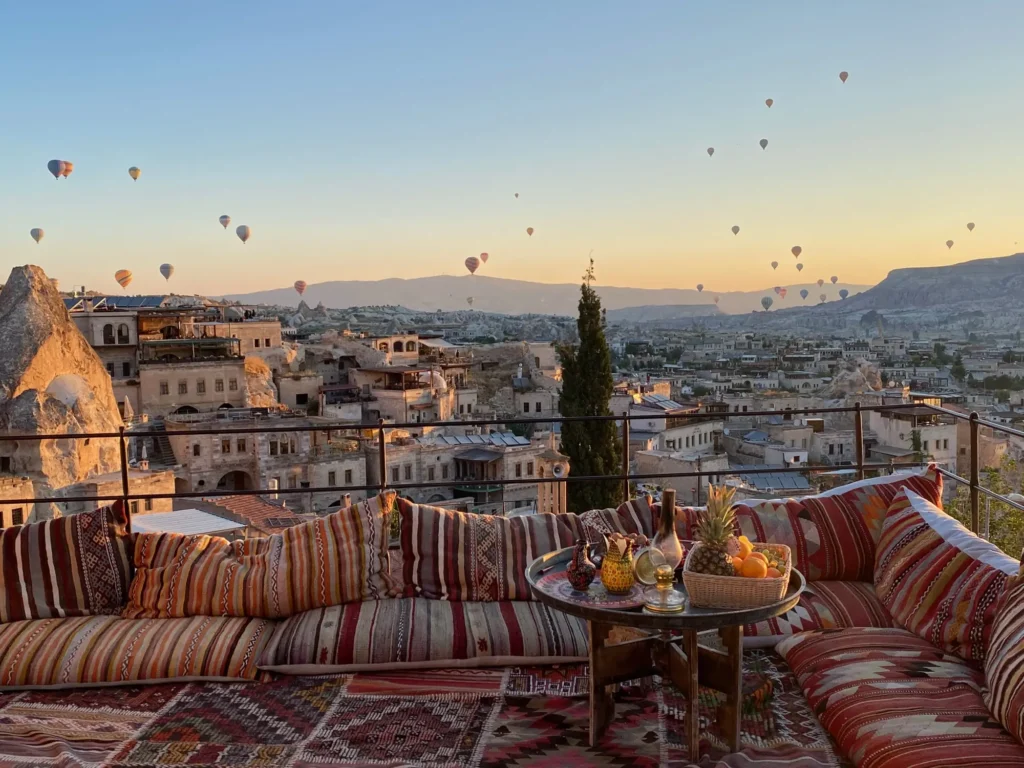 Una terrazza di Göreme all’alba, coi tappeti e le mongolfiere. Luglio 2022.