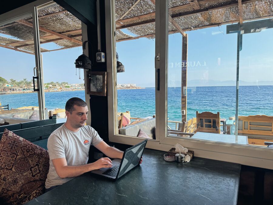 Christian Cannata al portatile in un caffè sul mare a Dahab